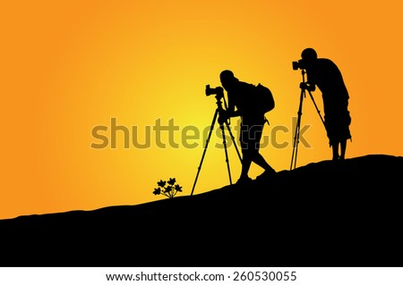 Silhouette of a photographer who shooting a sunset on the rock