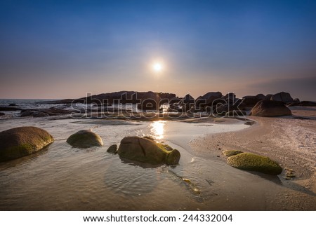 sun sea sand stone with clear blue sky