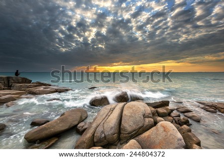Man fishing on The stone in The sea
