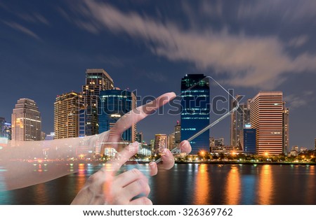 double exposure of female hand hold and touch screen smart phone, tablet,cellphone over city night light background.