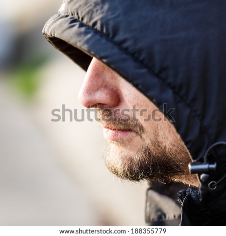 The man with short beard in a hood on a head