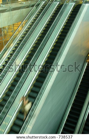Lone lady rushing down the escalator with hands on head (Blurred)