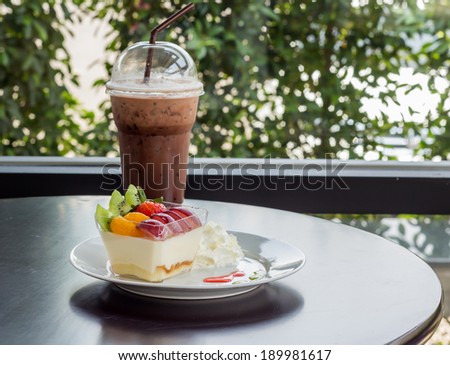 Delicious fresh fruit salad and Cocoa smoothie served on wooden