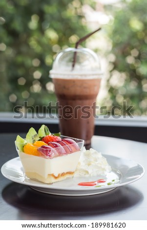 Delicious fresh fruit salad and Cocoa smoothie served on wooden
