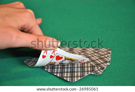 Women hand check the playing cards on a green table
