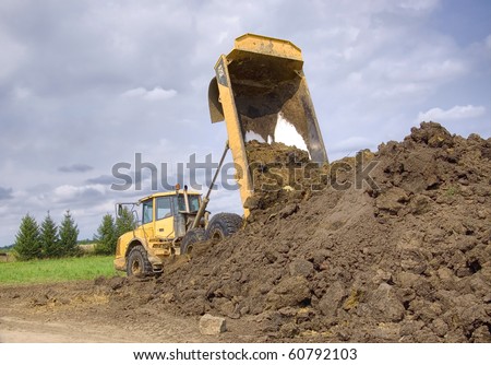 Heavy duty dump truck dumping soil