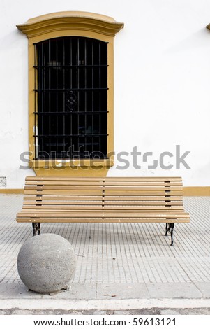 wooden bench with colonial window behind