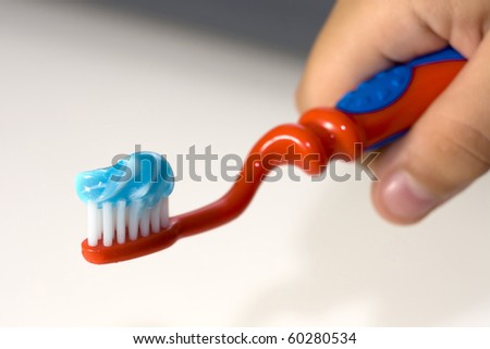 Toothbrush with toothpaste in a children hand