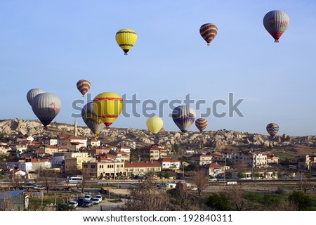CAPPADOCIA, TURKEY - MAY 4, 2014: Hot air balloons fly over the Goreme city on sunrise.