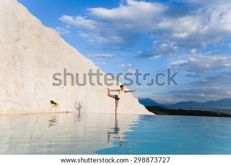 Warrior pose from yoga by woman silhouette on sunset in Pamukkale, Turkey