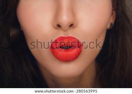 Young Woman Model with Perfect Clean Skin and Colorful Red Lips, High Fashion MakeUp. Sexy Kiss Burgundy Lips an Black Background