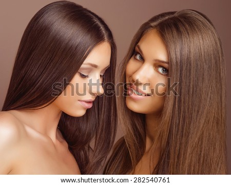 Portrait of two Beautiful Women with Long Brown Hair and Clean Skin. Fashion Beauty Model Girls with Make-up