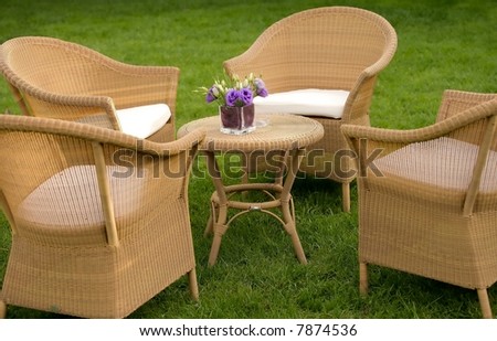Comfortable setting of straw sofas and table in a garden