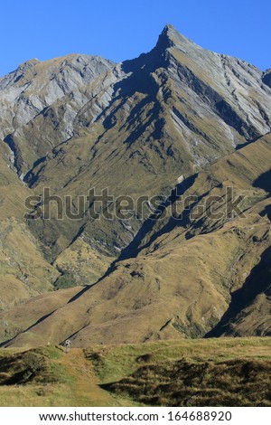 walker on footpath in Southern Alps, New Zealand