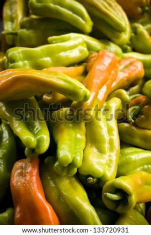 A pile of banana peppers sitting out in the sunlight