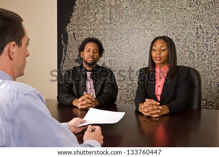 Young African American couple about to sign papers