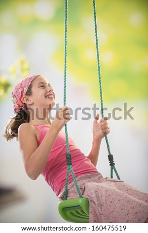 young girl on a swing in the garden