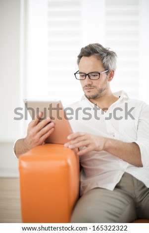 handsome man surfing on tablet on a couch