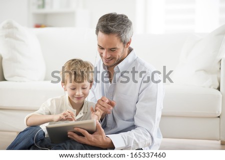 father and son sharing music headphones