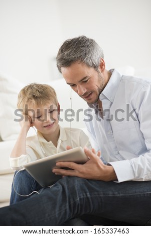 father and son sharing music headphones