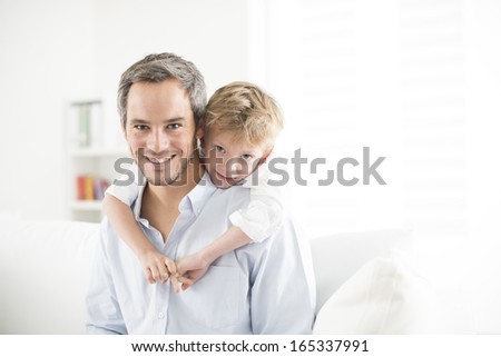 Father and his young son smiling and look the camera