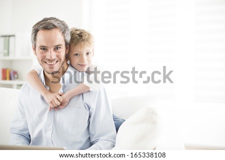Father and his young son smiling and look the camera