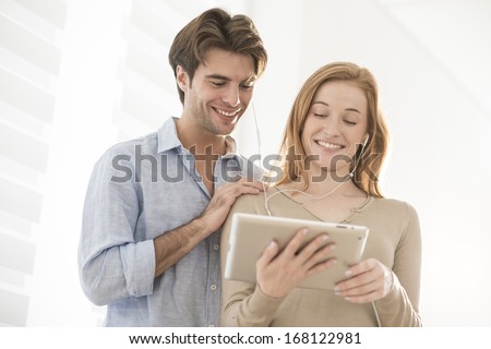 attractive couple sharing music on a tablet