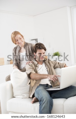 happy young couple using computer at home