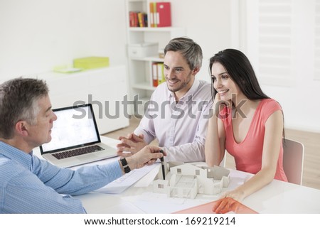 real estate agent showing a construction project to a couple