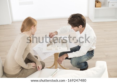 Couple studying a construction project with a model house