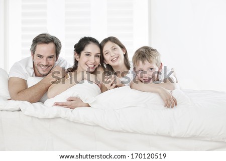 Happy Family Having Fun In The Morning In Parent\'S Bed