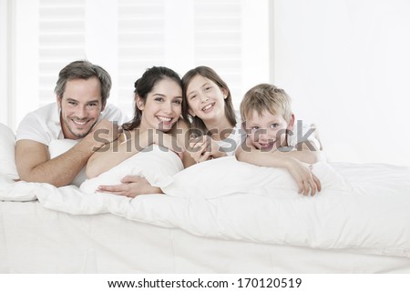 happy family having fun in the morning in parent's bed happy family having fun in the morning in parent's bed