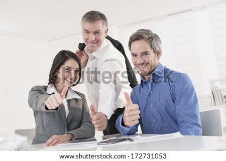 business team at office showing thumb up