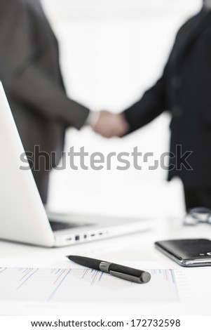 silhouette of a business people  with symbolic business objects in the foreground
