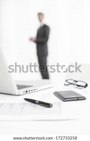 silhouette of a business man  with symbolic business objects in the foreground