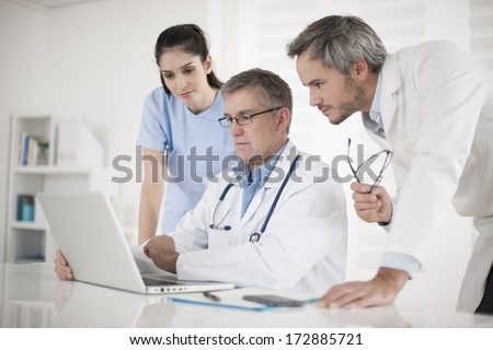 Medical Team Discussing Around A Computer