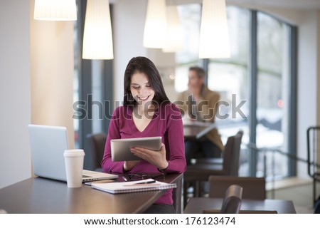 handsome woman using a digital tablet in a cafe handsome woman using a digital tablet in a cafe