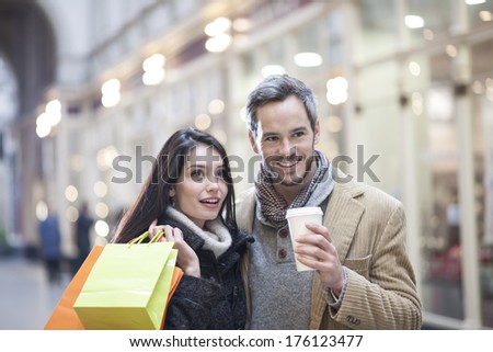 handsome couple doing shopping city lights in the background