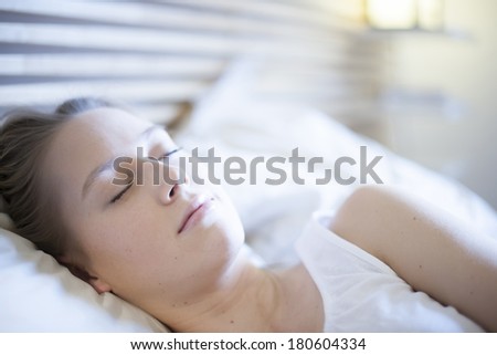 closeup of a beautiful young woman asleep in bed
