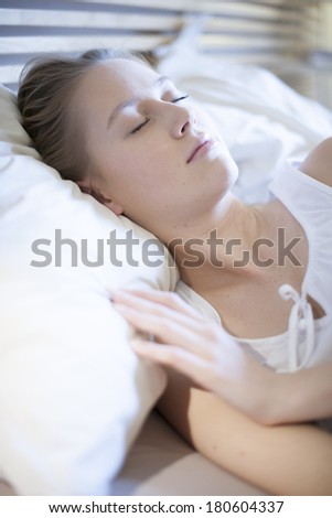 closeup of a beautiful young woman asleep in bed