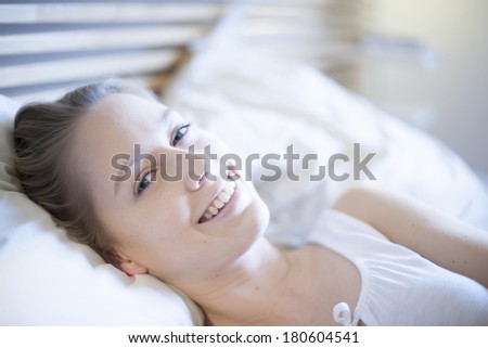 closeup of a beautiful young woman waking up in bed