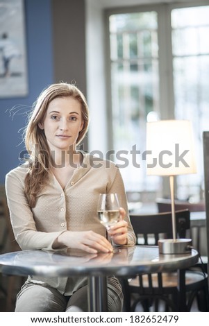 beautiful young woman drinking a wineglass alone in a bar
