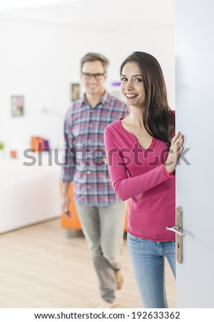 couple standing at front door to invite people at home