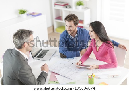 real-estate agent shows a build project  to a young couple