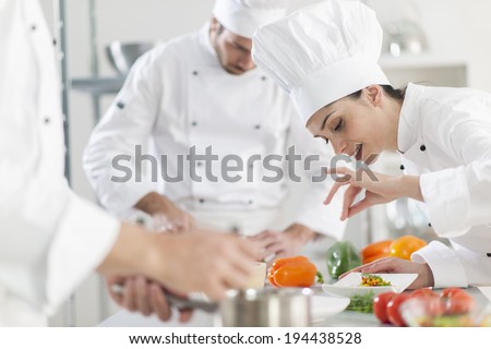 Portrait of a female chef preparing a dish carefully