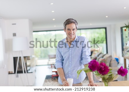 attractive man drinks a cup of coffee at home