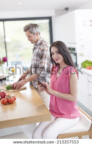 handsome couple in a kitchen, man at work and woman at phone