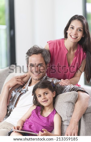 smiling family on a couch looking at camera