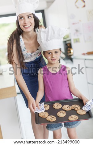 little girl and her mom offering a tray of cookies