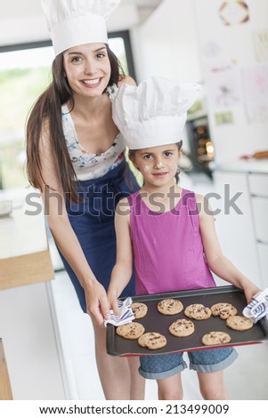 little girl and her mom offering a tray of cookies